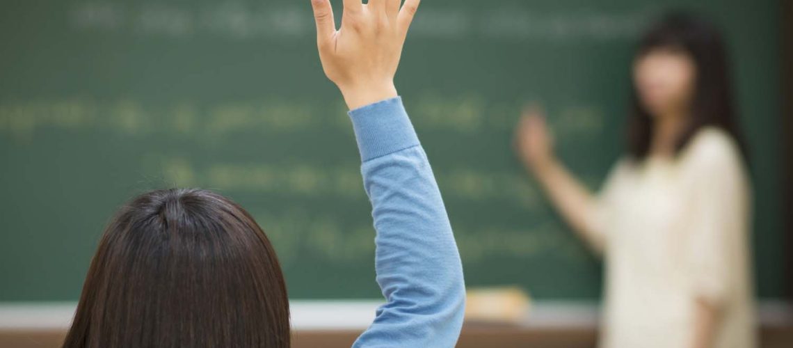 One student rises her hand and asks question